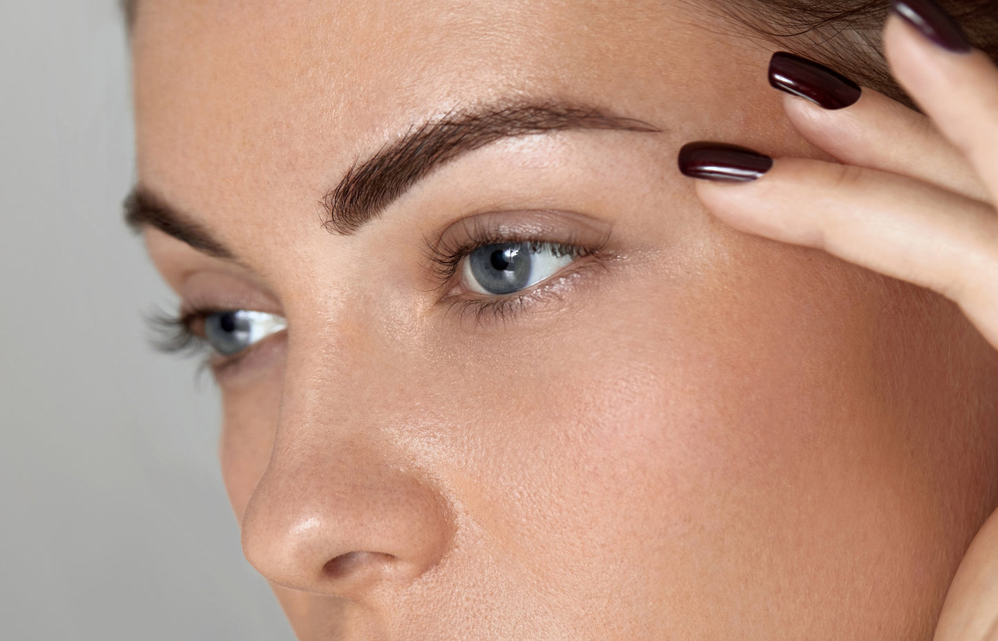 Close-up of a woman's face with a focus on her eye and eyebrow.