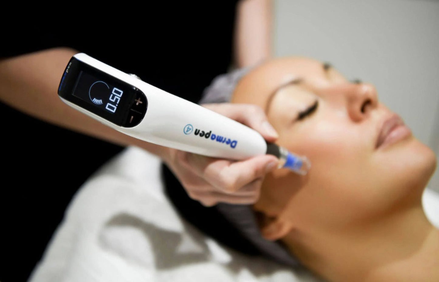 Woman receiving a facial treatment with a digital device.