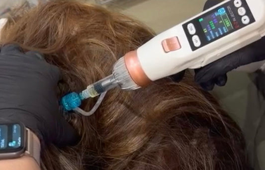 Person receiving a hair treatment with a device on a salon chair.