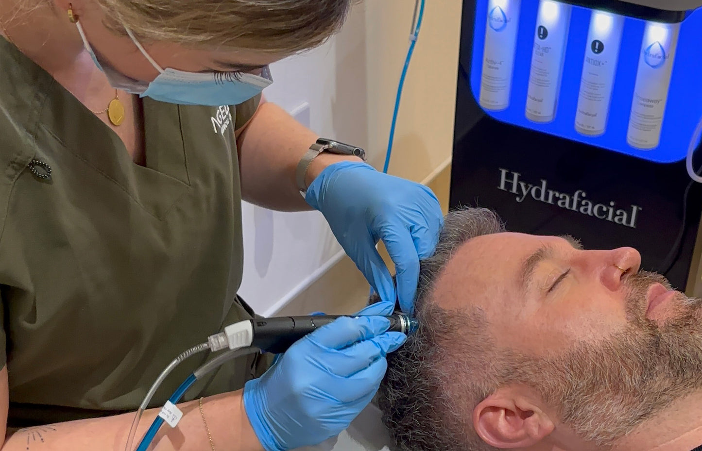 Person receiving a Hydrafacial treatment with medical equipment.