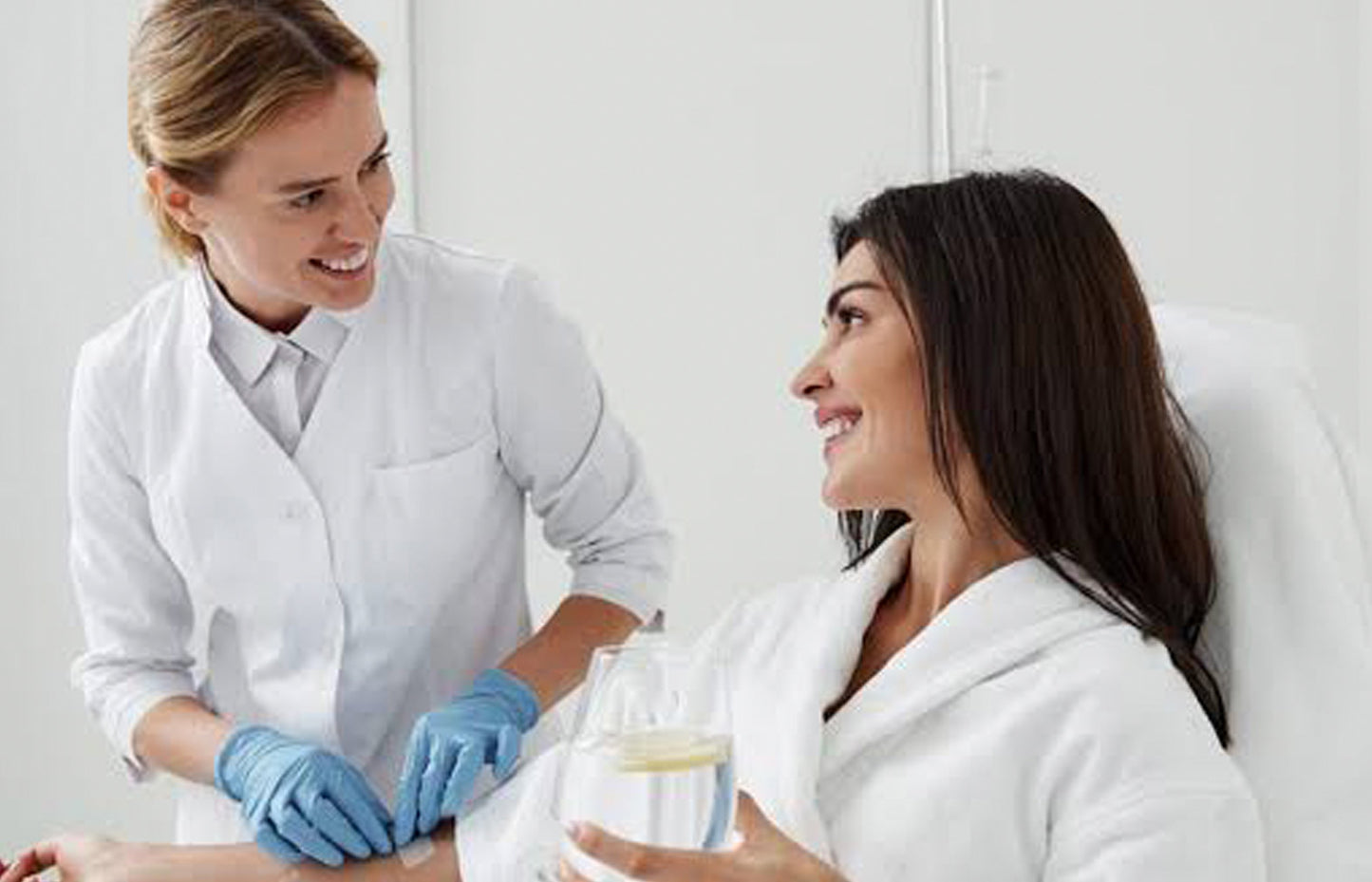 Woman receiving a skincare treatment from a professional in a clinical setting.