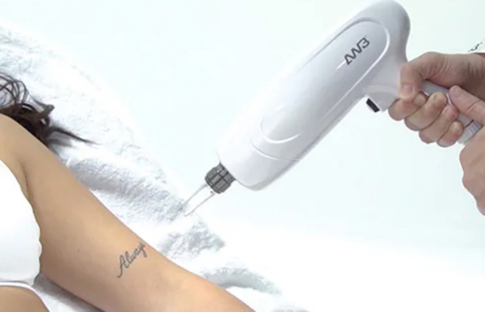 Person using a white handheld device on their arm with a blurred background